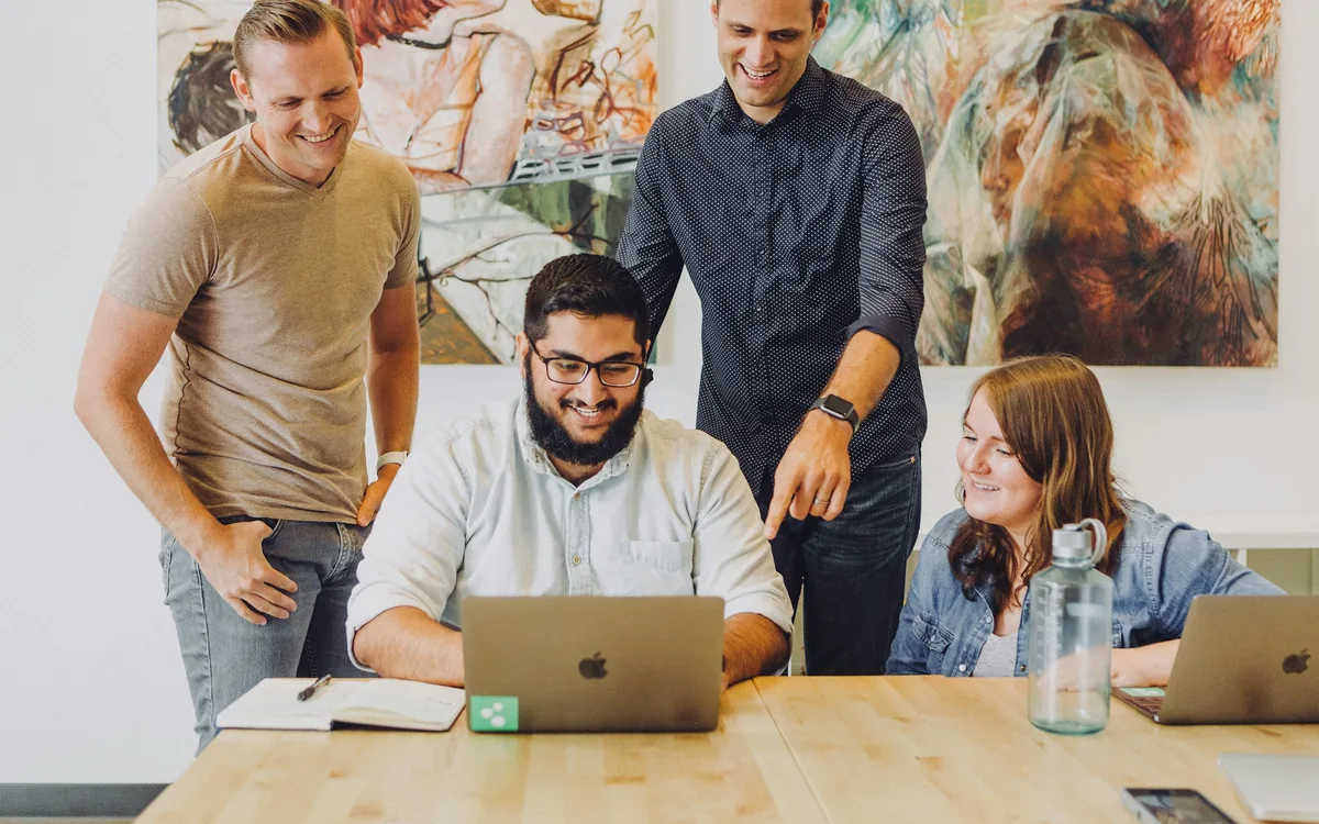 Agency team gathered around a laptop in a studio
