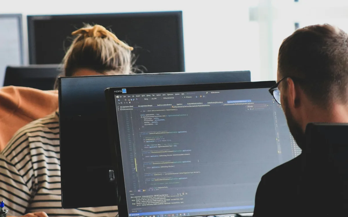 Two developers working at monitors in an open office